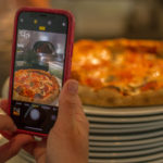 iPhone X being used to take picture of pizza
