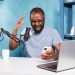 Furious african american blogger reading negative feedback on smartphone while recording video. Angry upset vlogger holding mobile phone and sharing bad news while streaming live